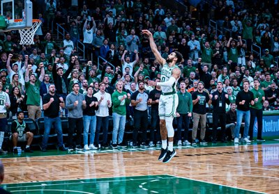 NBA东部决赛第七场决胜时刻的赛场照片，球员在三分线外起跳投篮，全场观众起立屏息